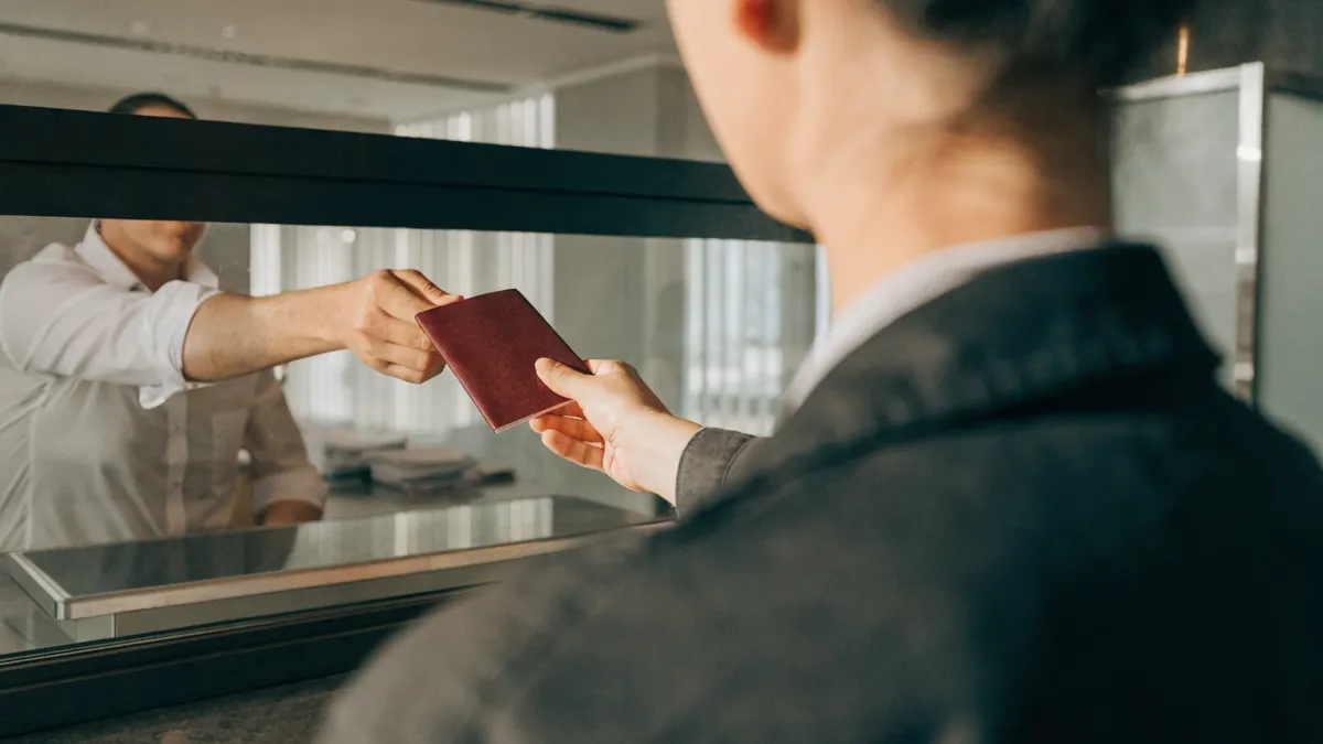 Een paspoort wordt overhandigd aan een medewerker aan de balie van een Spaanse bank