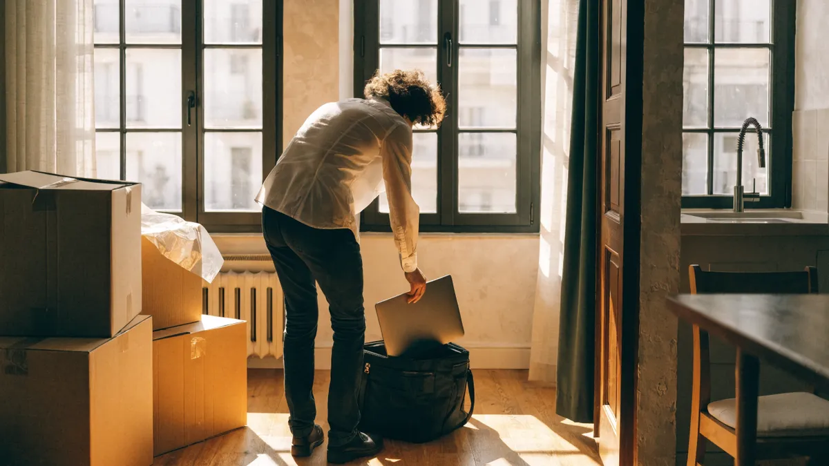 Professional unpacking a laptop in a bright new Valencia apartment