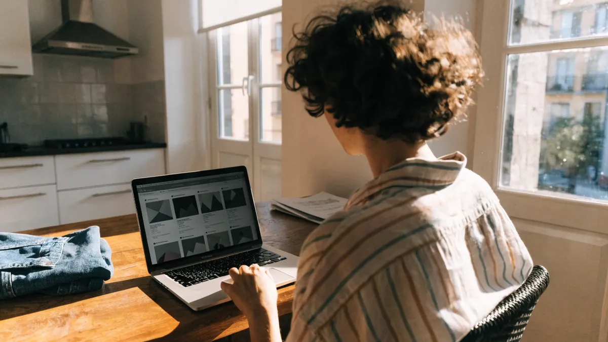 Browsing apartment listings on a laptop in a bright Valencia flat