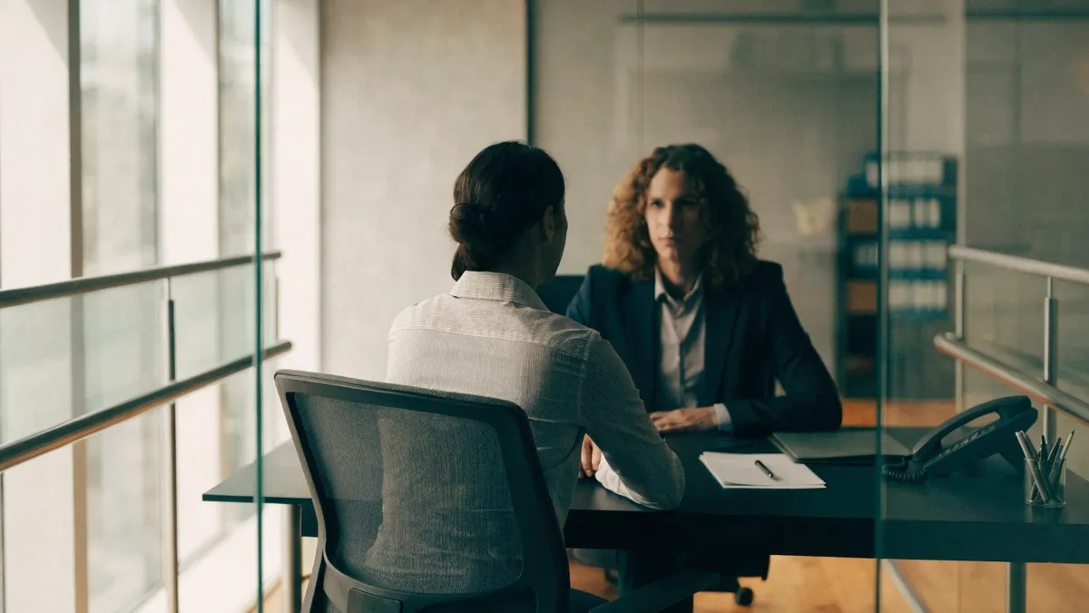 Klant met een adviseur aan een bureau in een Spaans bankfiliaal