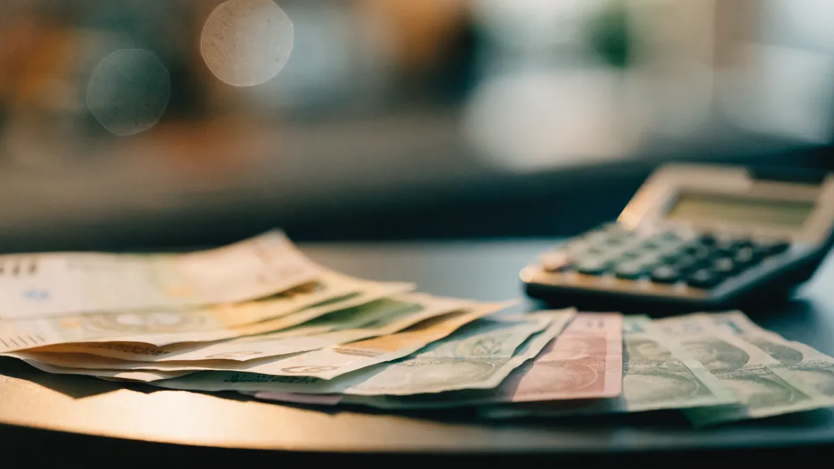 Euro- en pondbiljetten uitgewaaierd naast een rekenmachine