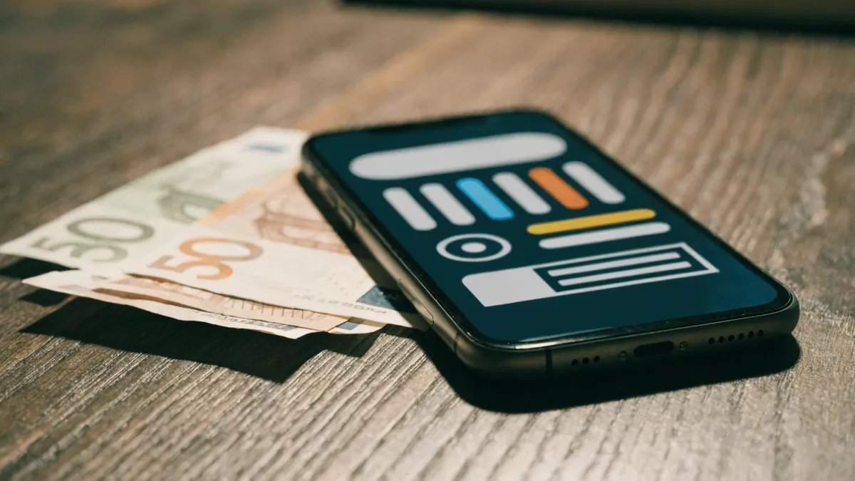 Telefoon met een app voor geldovermakingen naast eurobiljetten