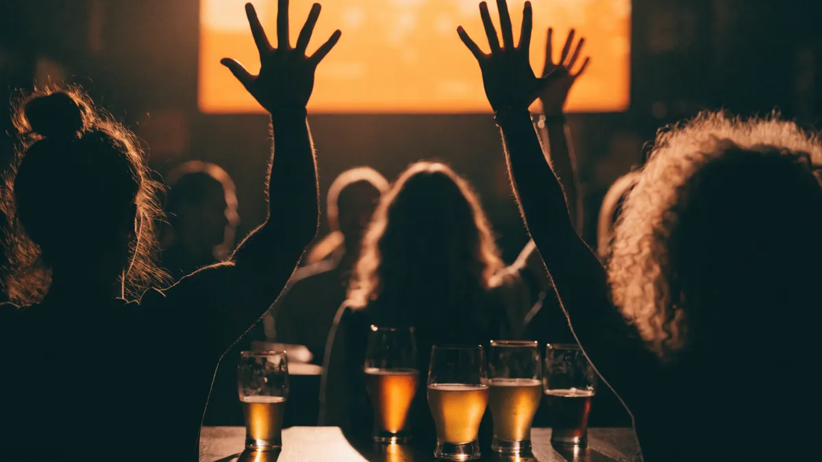 Amis vus de dos célébrant un but dans un bar